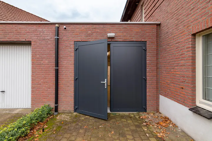 Openslaande kunststof garagedeur met loopdeur